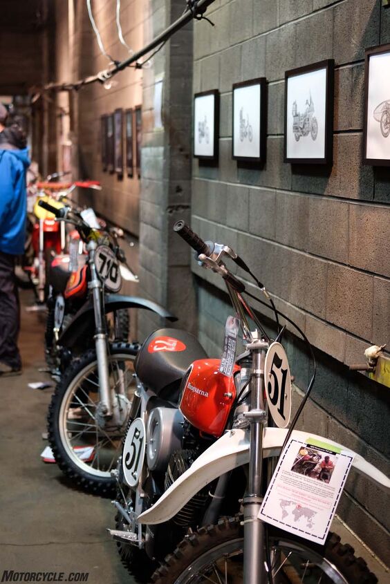the one motorcycle show 2017 report, Vintage race bikes line an upstairs wall beneath art by Carter Asmann