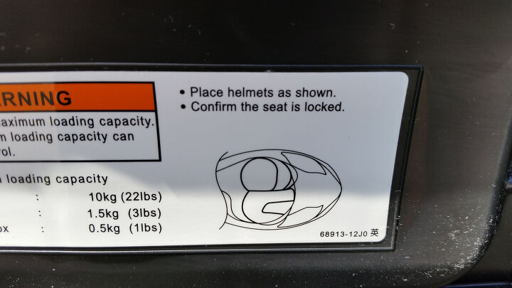 2014 suzuki burgman 200 abs first ride review, Many scooters say they can fit two helmets but the Burgman 200 is the first I ve seen with a diagram under the seat explaining exactly how to do it Clever