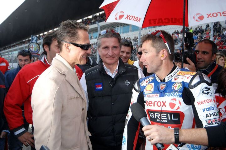 riding factory superbikes with michael schumacher, Michael Schumacher greets fellow multiple world champion Troy Bayliss at the Ducati rider s last WSBK race at Portimao
