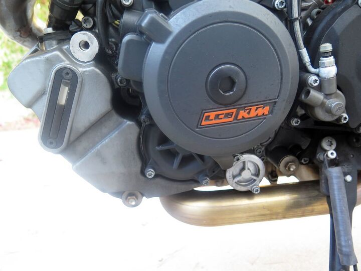 longtime companion ktm 1290 super duke r, The long vertical window on the left side of the engine makes it easy to gauge the oil level and its color at a glance Ours looks way past due for a change Not a drop of oil has been added over the last 3 134 miles The round silver thing under the clutch basket is the oil filter cover