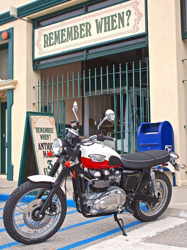 photographing motorcycles parked in front of places, Now and again the motorcycle and backdrop are a thematic match The retro Triumph Scrambler fits nicely in front of the antique shop with a finishing vintage touch from the blue mailbox