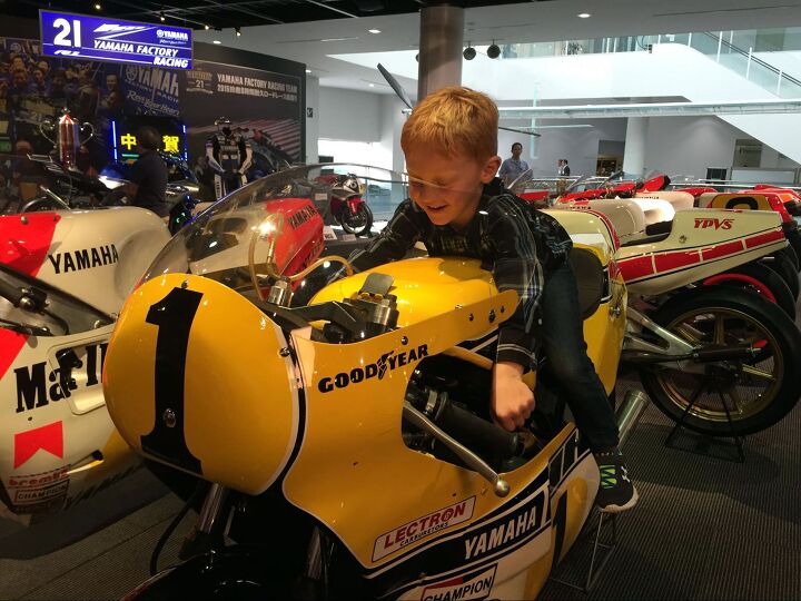 unsung motorcycle heroes 2 bob starr, Kenny Roberts Jr s son Logan tries one on for size at Yamaha Communications Plaza in Hamamatsu Japan