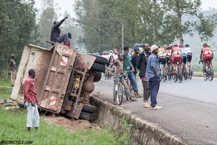 riding motorcycle support in the tour du rwanda bicycle race, In the chaos of Rwandan traffic a truck in the ditch is of little concern but does supply excellent seating for a passing bike race Photo by Mjrka Boensch Bees