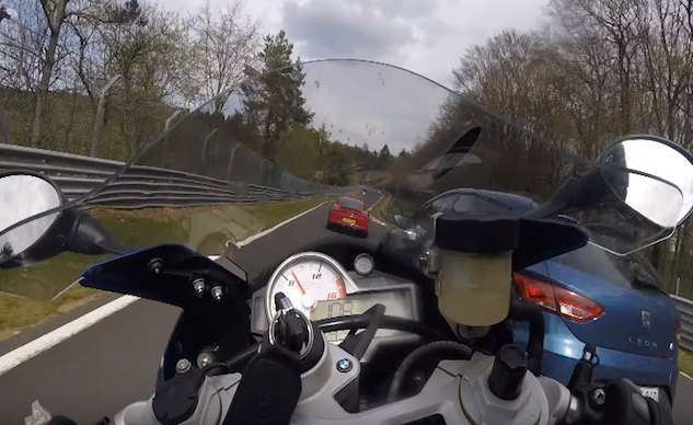 motorcyclist at nurburgring clipped by car and saves it