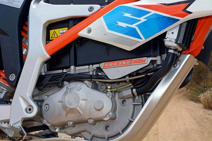 2017 ktm freeride e xc first ride review, From the upper right following the radiator hose downward brings you to the Freeride E s liquid cooled motor It s geared to a primary drive and jackshaft across to a countershaft and chain drive Above the motor in black is the 2 6kWh battery that simply requires backing out four bolts to remove A battery swap can be made in less than a minute The aluminum bash plate is lovely
