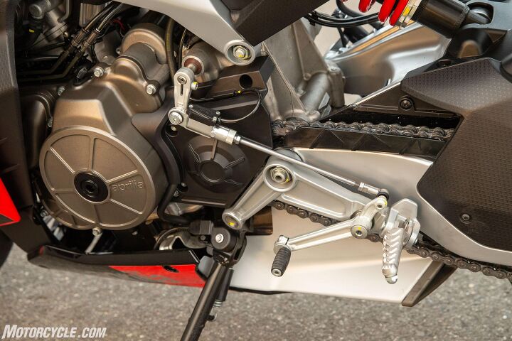 2021 aprilia rs660 review first ride, The compact nature of the motorcycle extends down to the engine where you can see the adjustable swingarm pivot bolting through the rear of the engine casing This picture also clearly shows the footpeg mounting directly through the swingarm pivot as well This helps meet the compact goals Aprilia set while keeping peg position relatively low and comfortable without sacrificing ground clearance But it s going to be a pain should you want or need to replace the pegs Note also the up down quickshifter