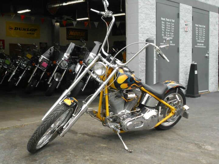 A custom chopper with forward controls and gleaming pipes, showcasing the intricate details that justify premium pricing.
