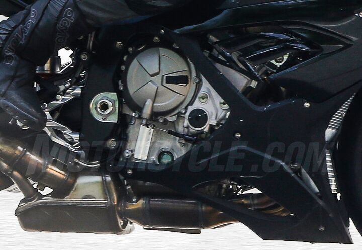 2018 bmw s1000rr spied, Header pipes merge into a collector presumably housing a catalytic converter before dumping into a sizable muffler pre chamber that helps reduce the size of the actual muffler that sits alongside the new swingarm The smaller diameter pipe exiting under a larger one is curious Also note how the exhaust chambers aren t surrounded by a bellypan fairing which should help them shed heat