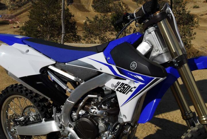 2014 yamaha yz250f first ride, The YZ250F s slim and flat layout adds to its ergonomic excellence Note the lack of a fuel cap on the tank The 2 1 gallon fuel cell is actually located low between the YZ s aluminum frame spars and toward the center of the seat The fuel filler is accessed through and easy to remove section at the very front of the seat