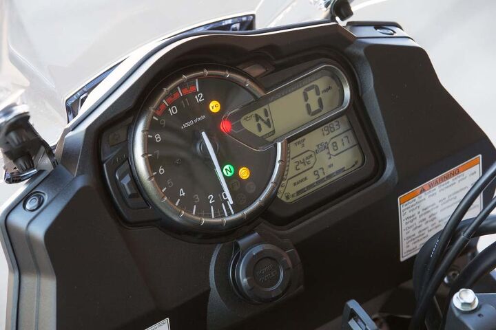 2014 suzuki v strom 1000 abs review first ride, The V Strom s instrument is legible but the one missing electronic rider aid component and corresponding readout we d like to see added is cruise control Note the easily accessible 12V power outlet