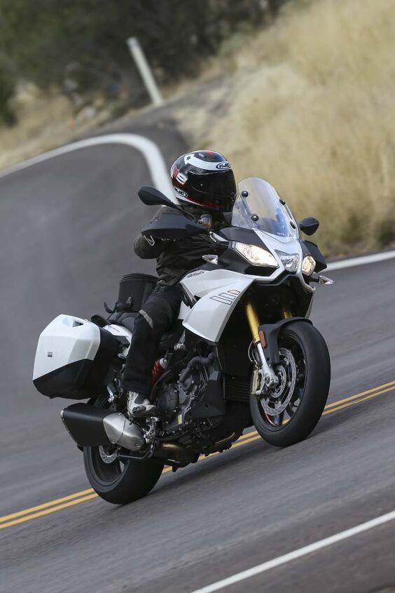 2015 aprilia caponord 1200 abs travel pack review video, Wide bars on the Caponord help throw the 599 lb fully fueled motorcycle into turns I had no ground clearance issues but a heavier more aggressive rider said he dragged hard parts Note the hand guards which lend to the A T personality