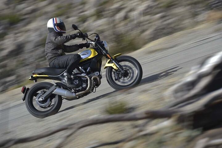 2015 ducati scrambler first ride review, Wide bars make muscling the Scrambler where you want it a cinch And don t worry Scrambler aficionados a high pipe is available as an optional accessory even if its headers are still exposed to bashing