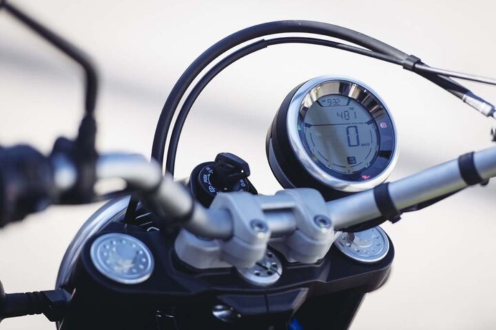 2015 ducati scrambler first ride review, A spartan offset gauge cluster is dominated by its digital speedometer The digital tach is under the speedo but is hard to read at a glance Clock two trip meters and odometer are present and with a few button presses the menu screen pops up where the speedo is Here you can change screen brightness and switch off the ABS among other things Two items you won t see are a fuel gauge or a gear position indicator