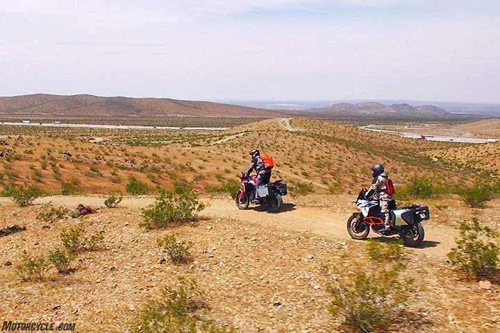 2017 honda crf1000l africa twin vs ktm 1090 adventure r, Cruising through the desert with Interstate 15 in the background we noticed that the KTM 1090 Adventure R s clutch and shift action do not feel as refined as the Honda Africa Twin s although we appreciated the KTM s slipper clutch function Both machines are equipped with six speed transmissions