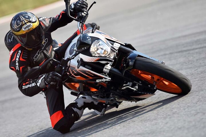 2015 ktm 390 duke first ride review video, The 390 Duke is super narrow between a rider s knees Above the headlight is an ultra mini windscreen that is more style than substance KTM s Power Parts catalog offers a larger one