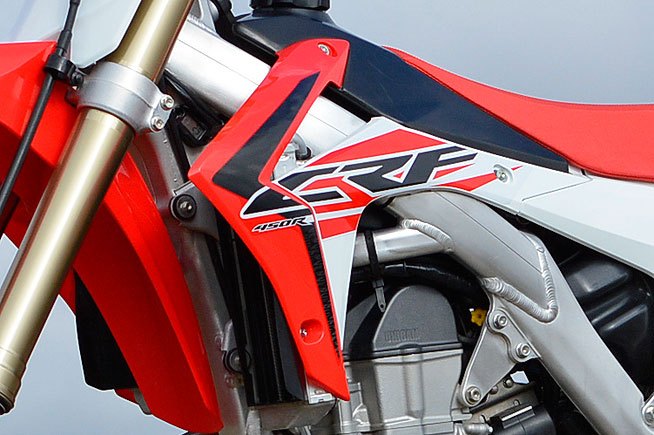 2016 honda crf450r first ride review, We re not fans of the CRF s angular radiator shrouds which tend to snag knee guards and boot tops during hard cornering The shrouds spoil an otherwise very good overall ergonomic package