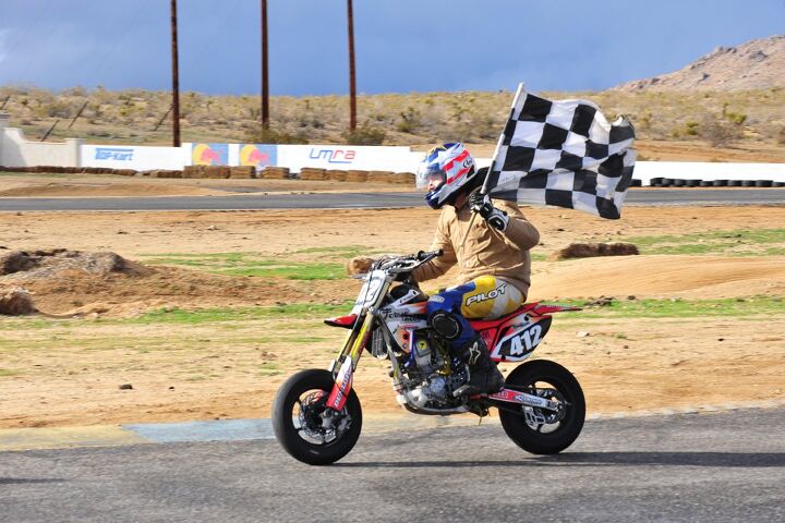 racing a honda crf150r is minibike racing the way it should be, Robert Perez taking the a lap of honor with the checkered flag and the race winning machine