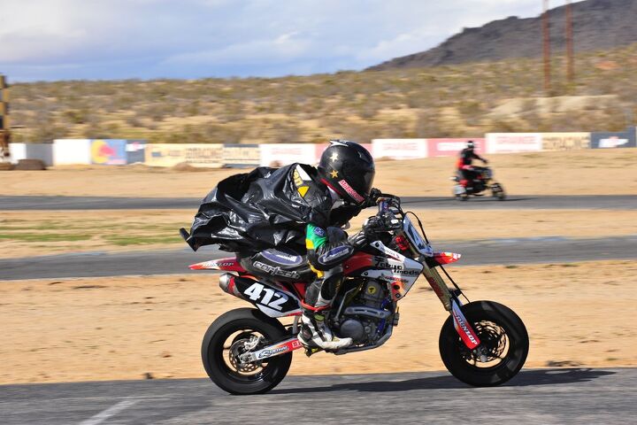 racing a honda crf150r is minibike racing the way it should be, Former AMA National Supersport champion and current Alpinestars graphic designer Austin DeHaven showing off the trash bag rain suit Don t expect it to appear in the Alpinestars catalog any time soon