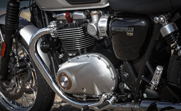 2016 triumph bonneville t120 first ride review, It needs mentioning that traditionally the Bonneville utilized a 360 crank whereas the new T120 has a 270 crank Note the coolant reservoir tucked out of sight behind the 6 speed transmission There s a hidden evap canister in there too Footpegs are designed to provide more legroom while decreasing cornering clearance Street Twin pegs without the downward bend can be swapped for those desiring more clearance