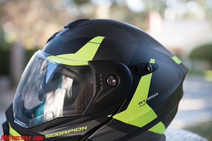 mo tested scorpion exo at 950 helmet review, A huge eye port makes for great visibility which comes in handy in all situations but especially off road The sliding tab behind the side pod operates the SunVisor while a closer look at the side pod reveals the screw needed to replace or remove the shield