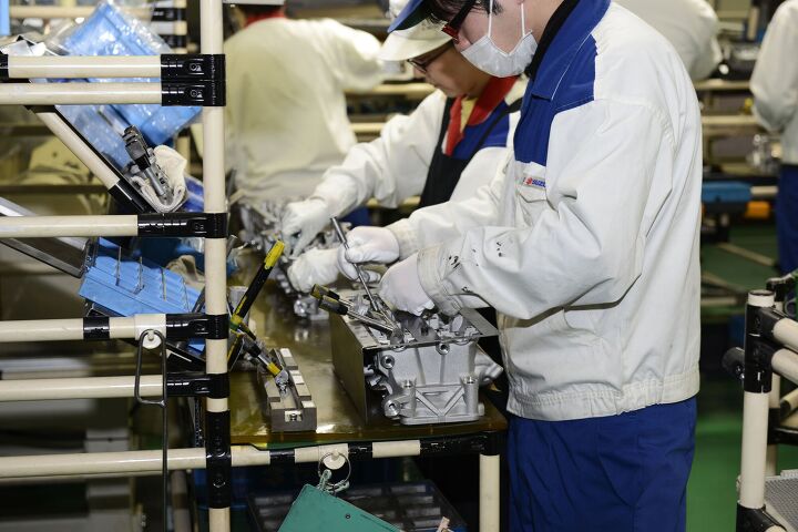 suzuki factory tour part 2 takatsuka engine manufacturing plant, Next we walked to an adjacent building where the engines are assembled passing by pallets of parts from reputable subcontractors like Mahle and Denso Here a GSX R1000 cylinder head is put together by fastidious workers