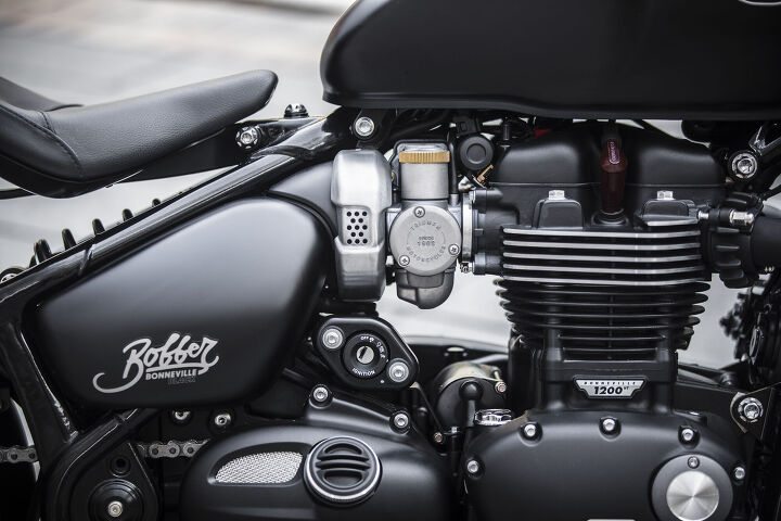 2018 triumph bonneville bobber black first ride review, The Black is put together cleanly with all wires and cables neatly tucked out of sight Other nice touches include carburetor looking throttle bodies and a relocated ignition switch that further cleans up the cockpit