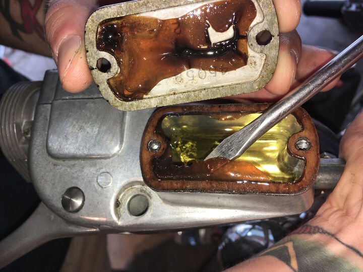 mo wrenching bleeding brakes after long term storage, Cracking the front brake master cylinder reservoir open this is what I found Congealed and discolored brake fluid with a bunch of sediment at the bottom no bueno