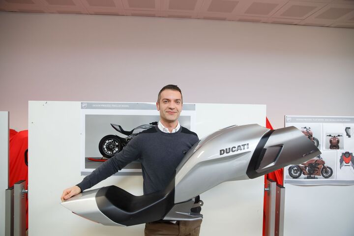taking a peek behind the crimson curtain, Designer Giovanni Antonacci holds a medium density foam model of the tank seat and tail section of the Diavel an exercise in understanding proportions