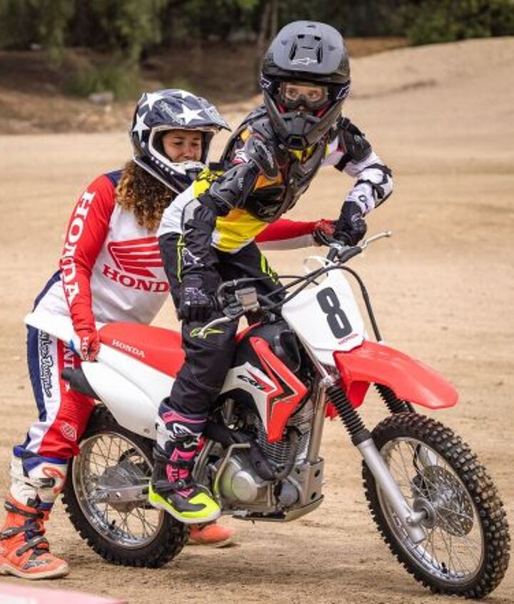 making a rider teaching your kid to ride, Here the coach helps with proper body position for turning