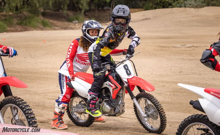 making a rider teaching your kid to ride, Here the coach helps with proper body position for turning
