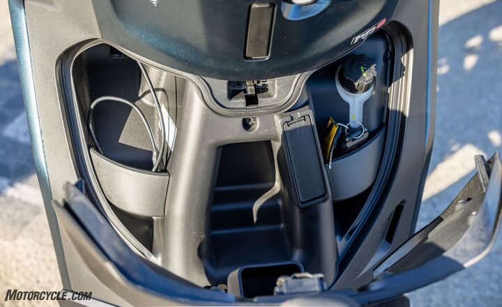 showdown 2022 piaggio bv400 vs suzuki burgman 400, This hidden compartment in the Piaggio s leg shield features a USB port on the left but it s just big enough to hold a phone Coolant reservoir is seen on the right