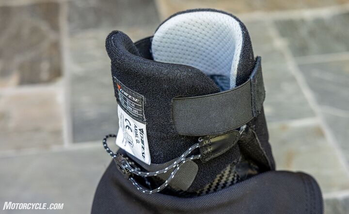 mo tested dainese axial gore tex boots, This shot from the front of the boot shows the speed lace that cinches down across the ankle for a snug non restrictive fit The elastic straps on the top hold the tongue of the boot which is at the rear up against the back of the rider s leg to make it easier to zip the rear entry s closure A little bit of the Axial Distortion Control System s carbon aramid bracing is visible below the speed lace