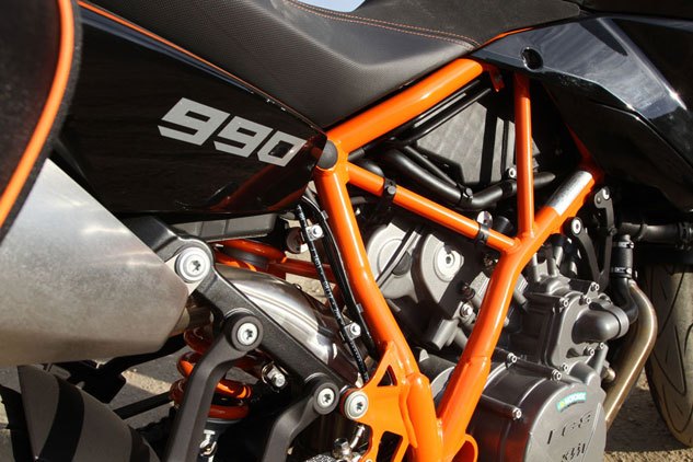 2013 middleweight sport touring shootout video, KTM s 999cc Twin is the eldest motor of the group The 60 degree Vee motor is counterbalanced but its throbby vibes are omnipresent To calm highway vibration KTM appears to have fitted the SM T with tall gearing