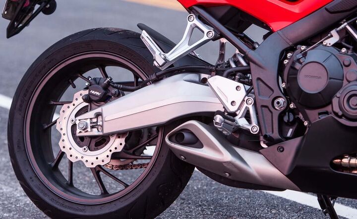 middleweight intermediate sportbike shootout video, Details like the stylized steel frame and aluminum swingarm the only one of the group are nice touches on the Honda as is the clever exhaust cover hiding what would otherwise be an exposed and ugly exhaust canister