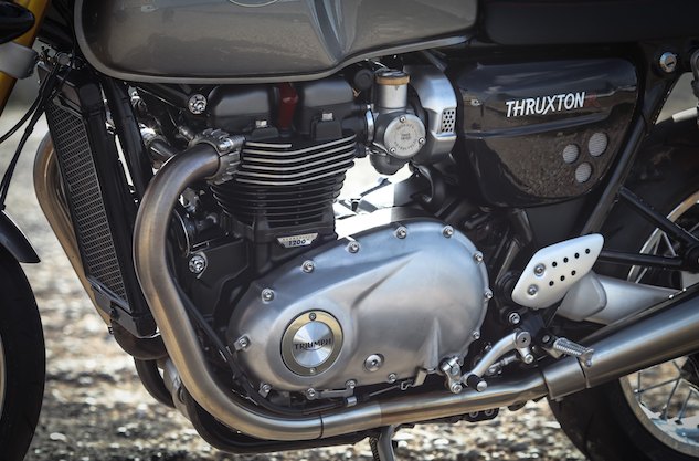 2016 triumph bonneville thruxton r first ride review, The radiator of the new liquid cooled 1200cc Twin is barely more apparent than the oil cooler on the outgoing model The engine compartment is tidy without any external plumbing uglifying its profile The faux carburetors of the new EFI look the vintage part The evap canister is there can you find it