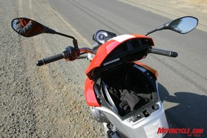 2009 aprilia mana review motorcycle com, The Mana swaps out usual fuel tank spot to a mostly under seat location with the faux tank serving as a voluminous storage compartment One full face helmet will fit in the tank storage compartment