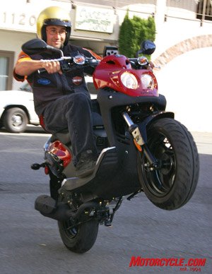 summer of scootin, This proves that yes wheelies are possible with scooters this time aboard a 110cc two stroke Rattler that features a remote reservoir adjustable shock digital instruments front disc brake and nimble handling Price tag is about 2600