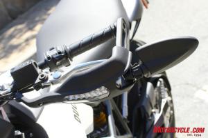 2010 aprilia dorsoduro 750 vs ducati hypermotard 796 motorcycle com, Slim LED turn signals integrated into hand guards and folding bar end mirrors are a carryover from the 796 s bigger brother the Hypermotard 1100