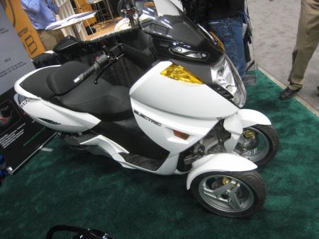 2011 indy dealer expo report, Electric scooter manufacturer Vectrix showed of its new VX 3 with Piaggio MP3 like tilting dual front wheels It s currently being evaluated by the LAPD