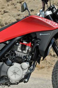 2013 husqvarna tr650 review motorcycle com, BMW s G650 motor gets an Italian style hot rod treatment note the cylinder s red head a nod to Ferrari s Testarossa to transform it into a livelier and more powerful engine