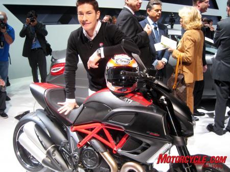 2011 ducati diavel review almost motorcycle com, Nicky Hayden the 2006 MotoGP world champion leans on the Diavel shortly after making a grand entrance at the LA Auto Show He may be smiling because he likes the bike or it might be because he was just told he ll be getting an AMG Mercedes as part of a new sponsorship agreement