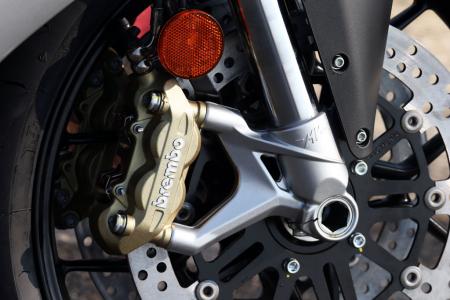 2013 mv agusta f3 675 review video motorcycle com, The artfully scalloped lower fork leg is an example of MV Agusta s attention to detail even on a relatively low cost model like the F3 Brembo calipers are two piece blocks bolted together rather than fashionable monoblocs to save a few euros