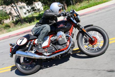 2011 moto guzzi v7 racer review motorcycle com, Duke demonstrates the lean angle you ll attain before hard parts begin gouging the pavement