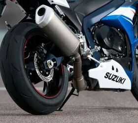 2012 suzuki gsx r1000 review video motorcycle com, The rear of the GSX R1000 reveals a missing left muffler as seen on the 2011 model Also exhaust plumbing underneath the engine is cleaned up dramatically with the elimination of the exhaust chamber seen last year