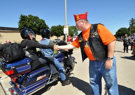 american legion legacy run raises 360k, American Legion National Commander Clarence Hill greets one of the participants of the charity ride