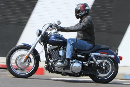 2012 harley davidson dyna super glide custom review motorcycle com, The SGC s rider triangle is generally a good fit for a variety of rider sizes but as you can see here the short peg to seat distance positions a rider s knees high well above the rear portion of the fuel tank
