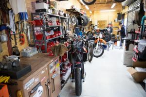 deus ex machina video, Elsewhere in the shop are some of Woolie s other projects including his personal Aprilia SXV550 in the foreground converted to full supermoto trim with a host of go fast parts It s a hoot he says