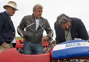 legend of the motorcycle postponed, Lifetime Achievement Award recipient Giacomo Agostini center inspects a bike with two judges
