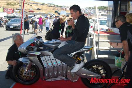2010 red bull u s grand prix at laguna seca event report, Michael Czysz takes notes while sitting aboard his remarkably attractive E1pc electric powered motorcycle Czysz would take the win in the FIM e Power electric motorcycle race with a last seconds pass on Michael Barnes whose bike simply ran out of power yards from the finish