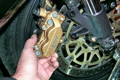 how to change your motorcycle tires motorcycle com, On 17 inch rims you will probably have to remove both front brake calipers in order to get sufficient rim clearance for wheel removal